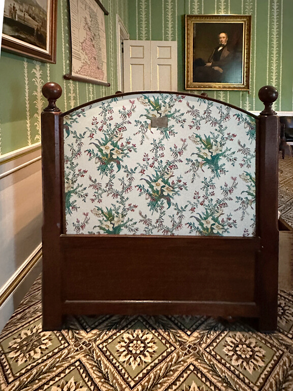 Kensington Palace Interiors with green striped wallpaper, an antique floral screen, and a vintage daybed layered in British design.