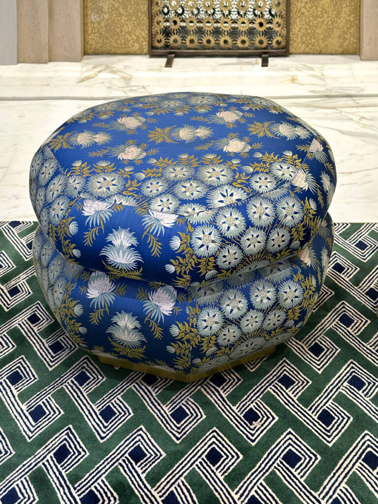 Cartier Mansion New York bold blue floral upholstered stool on green geometric carpet showing layered pattern and color