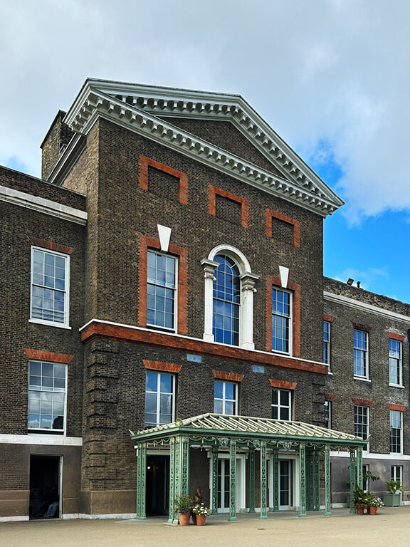 Historic Georgian brick building with light green trim at Kensington Palace in London.