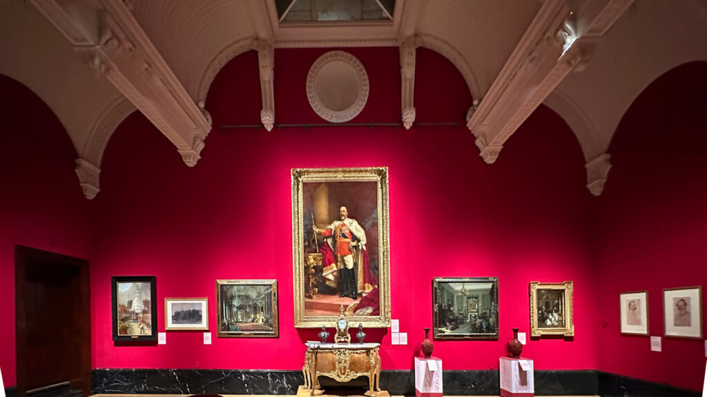 Edwardian Art Buckingham Palace exhibition room inside the King’s Gallery featuring large-scale paintings and central display cases.