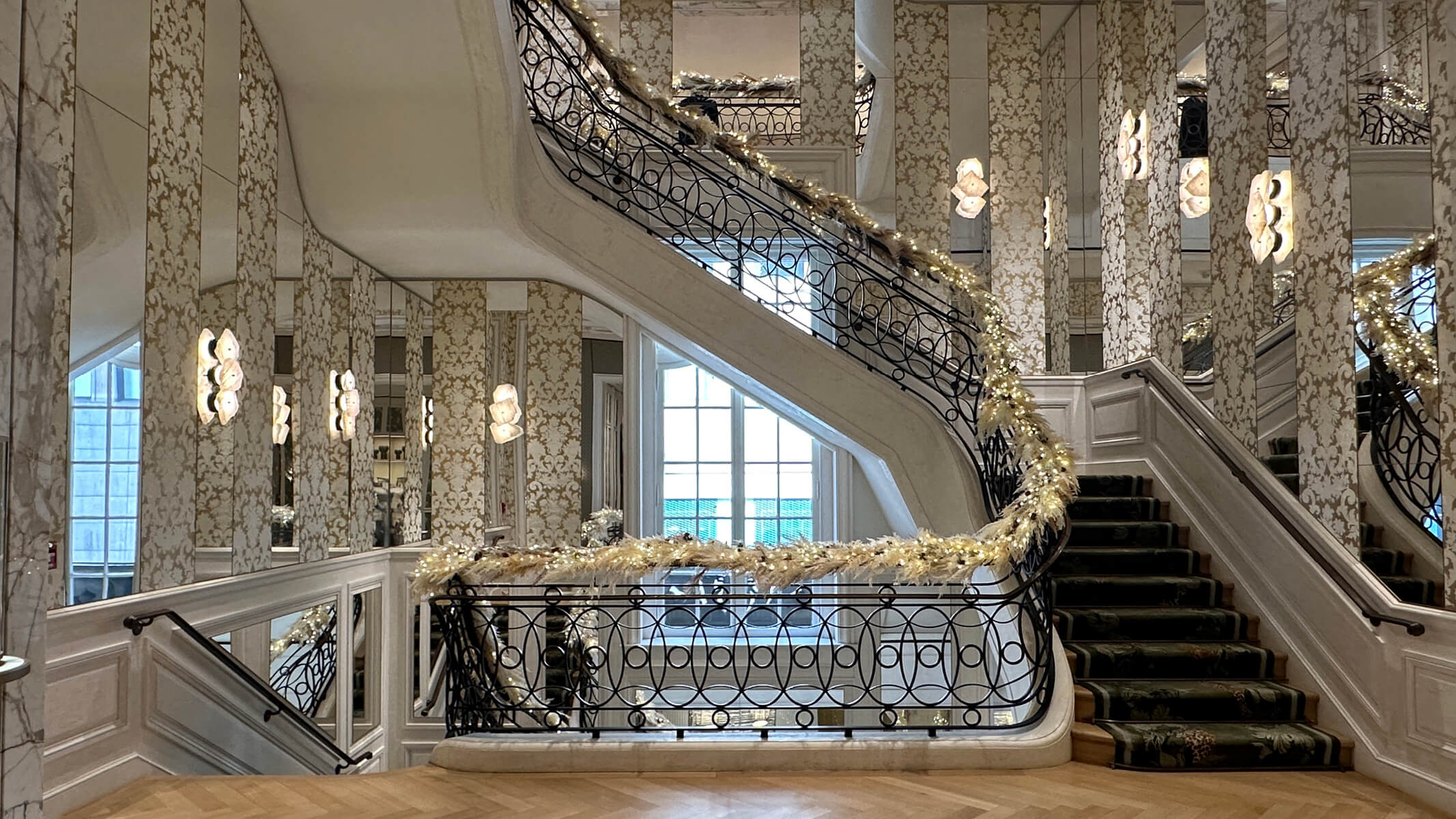 Cartier Mansion New York staircase with mirrored panels, damask wallpaper, and wrought iron railing