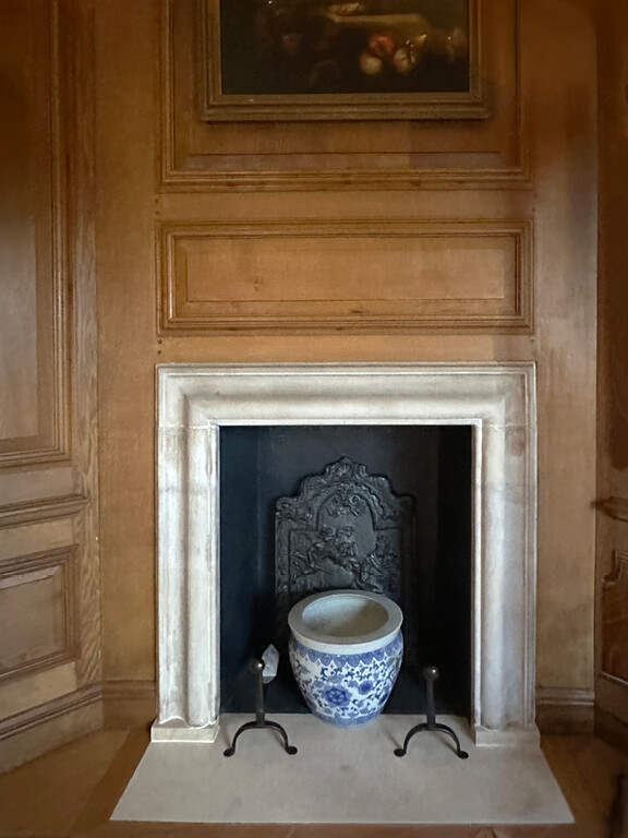 Kensington Palace Interiors featuring a historic fireplace in the Queen’s Dressing Room with natural oak paneling.