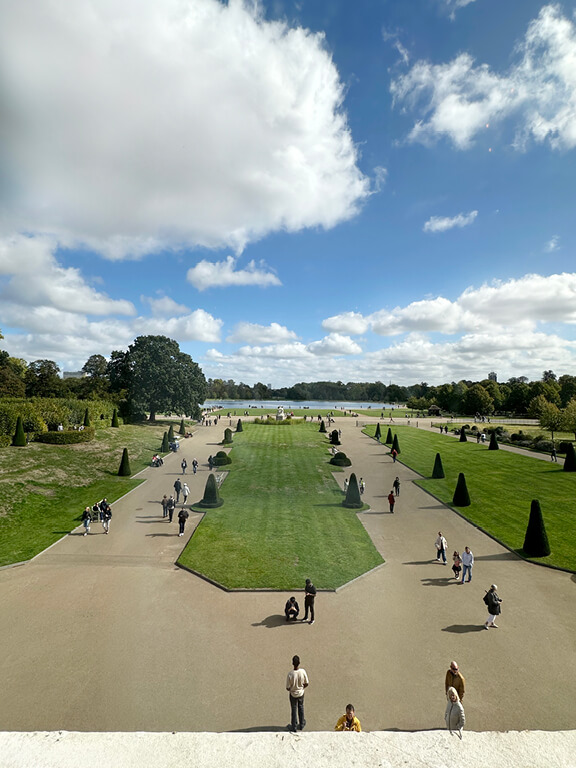 Formal gardens surrounding Kensington Palace in London, framed by historic architecture and landscaped paths.