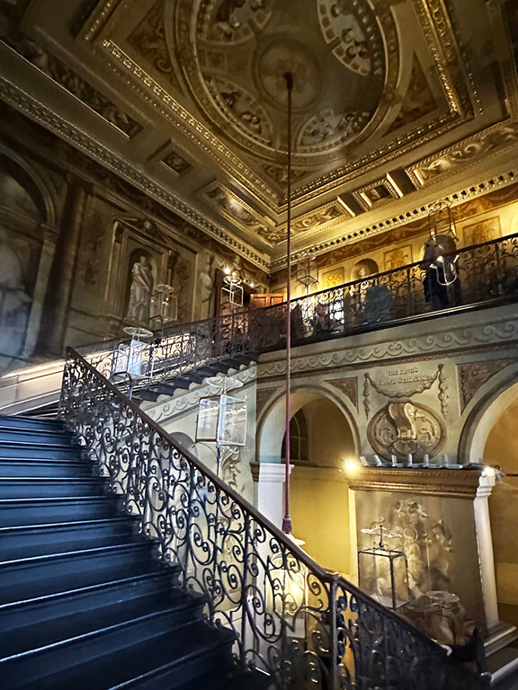 The King’s Staircase at Kensington Palace featuring painted figures, decorative walls, and historic architectural detail.