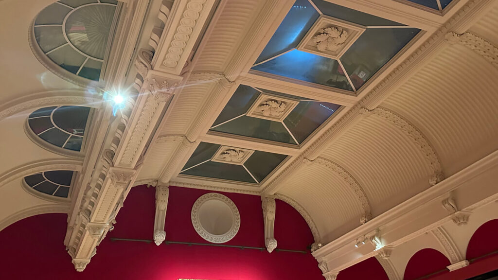 Edwardian Art Buckingham Palace exhibition room inside the King’s Gallery showing large-scale paintings and display cases.