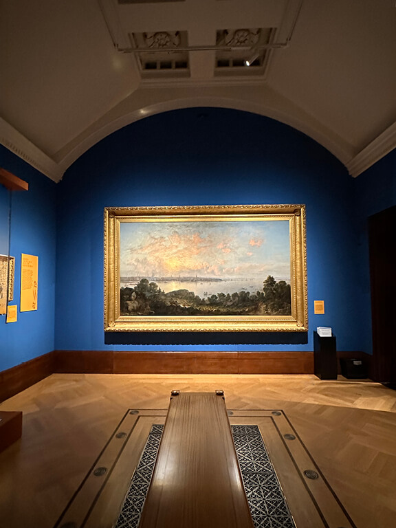 Edwardian Art Buckingham Palace landscape paintings displayed along the blue gallery wall inside the King’s Gallery exhibition.