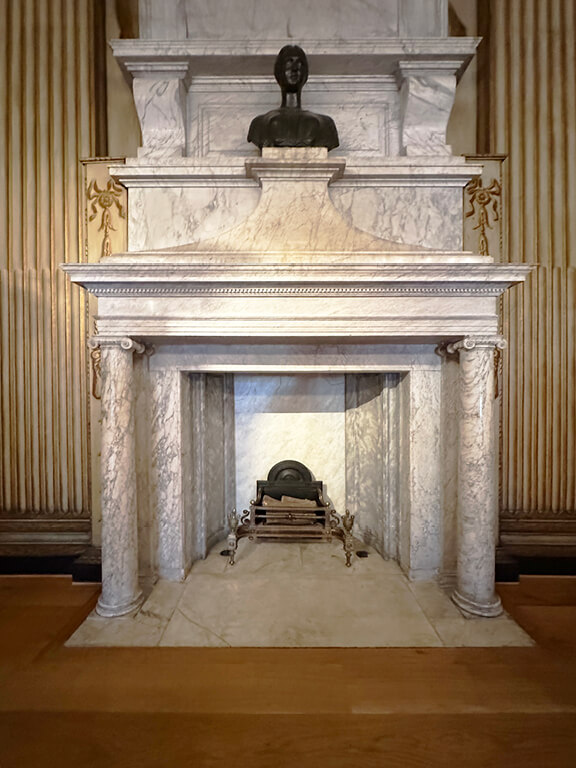 Kensington Palace Interiors featuring a marble fireplace topped with a classical bust in a historic room.