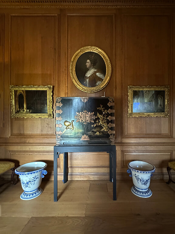 Kensington Palace Interiors featuring natural oak paneling paired with blue-and-white Delft pottery in a historic room.