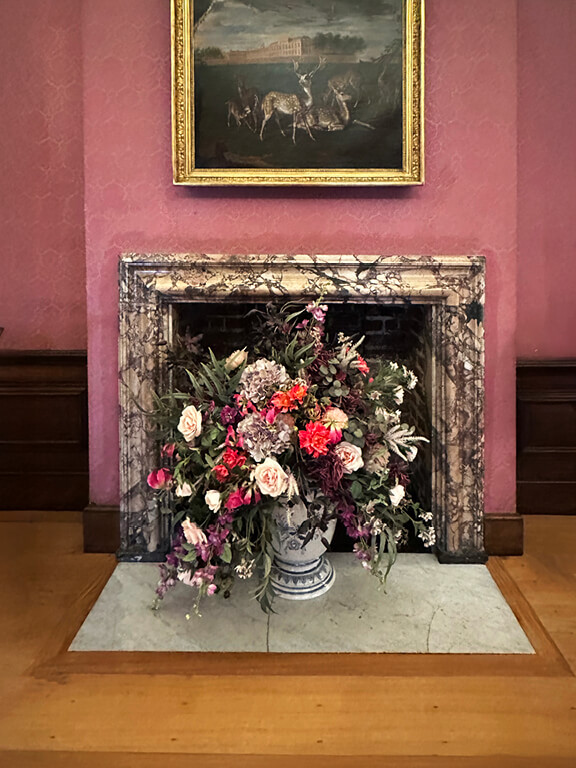 Pink damask wallpaper paired with a marble fireplace in the Queen’s Apartments at Kensington Palace.
