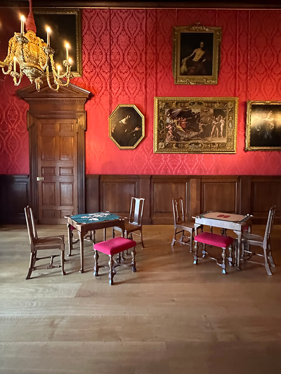 Kensington Palace Interiors featuring a red damask room furnished with antique pieces in a formal historic setting.