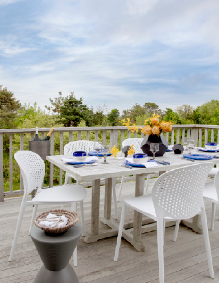 Small deck at a 70s surf shack renovation in Edgartown, Martha’s Vineyard, featuring a new space for a dining table. Highlighting New England interior design in a coastal outdoor setting.