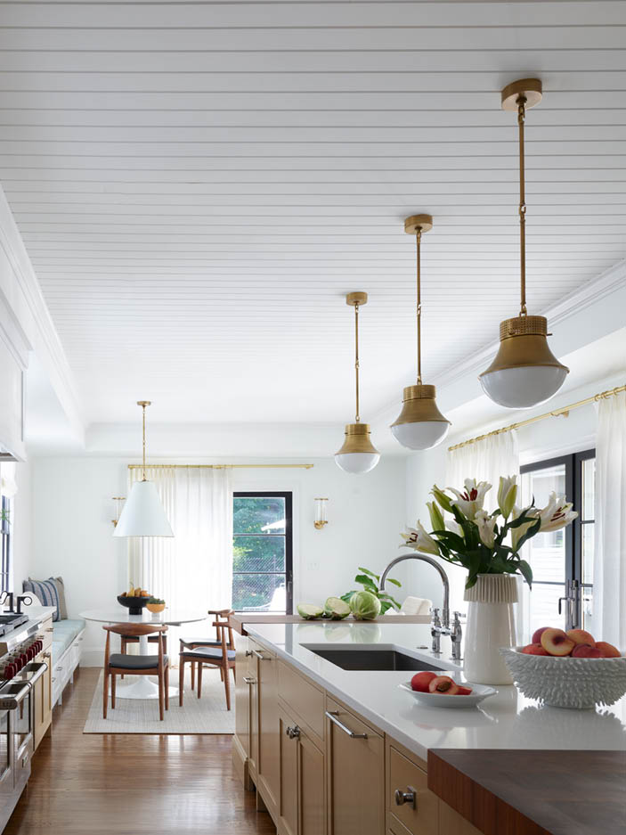 Modern kitchen in historic Hingham home with natural oak cabinets, walnut butcher block counter, brass pendants, shiplap ceiling, and black stools. Sarah Scales Design Studio is a full-service design Boston firm. 