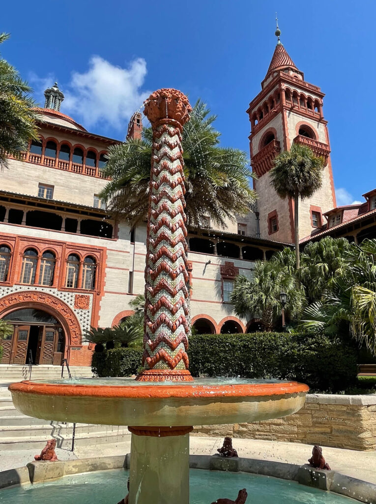 The main entrance to Flagler College featuring a curved entryway, intricate window and door trim details, and a unique water feature in the main courtyard.