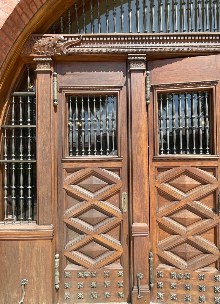 A beautifully crafted wooden entrance door with intricate details at the main building of Flagler College in St. Augustine, Florida.