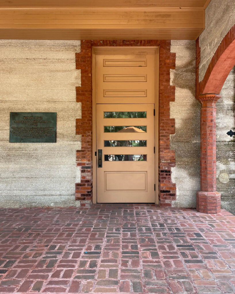 A unique door with intricate details and a window located on the backside of Flagler College in St. Augustine.