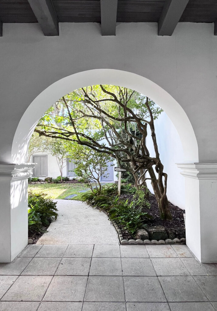 Perfectly white stucco arched entryway leading to a quiet garden in a private property in St. Augustine, Florida.