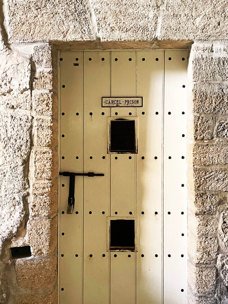 An old wooden door inside a military structure with exposed bolts and original hardware.