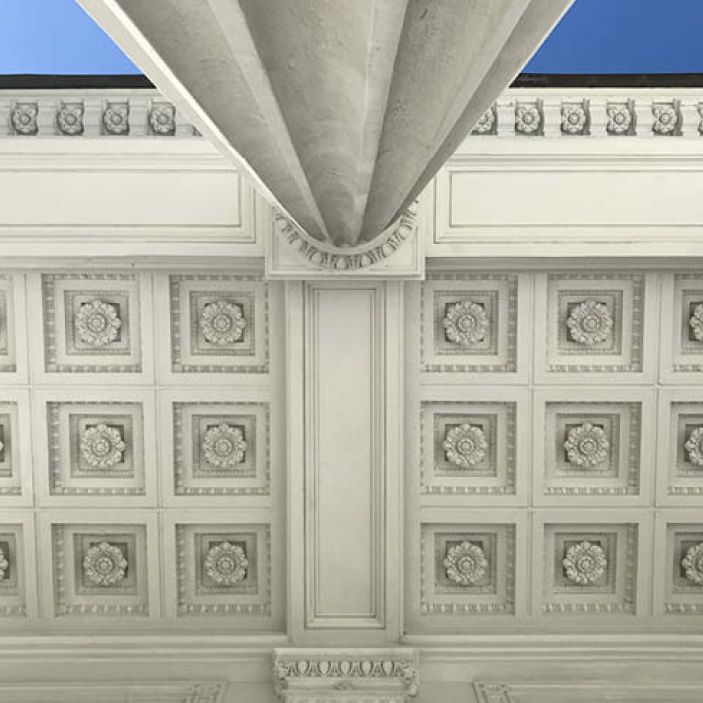 Classic Greek columns at the historic Flagler Mansion in Palm Beach, showcasing unique fluted details, cornices, and intricate ceiling panels against a bright blue sky, offering Boston Interior Design Inspiration.