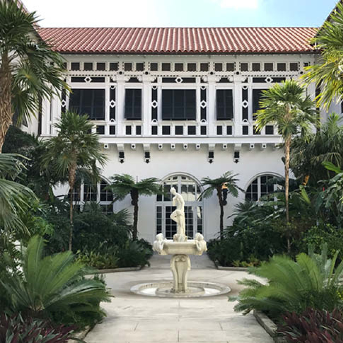 Classic garden courtyard at Flagler Mansion with limestone pavers, carved garden sculptures, and a tiled clay roof, offering Boston Interior Design Inspiration.