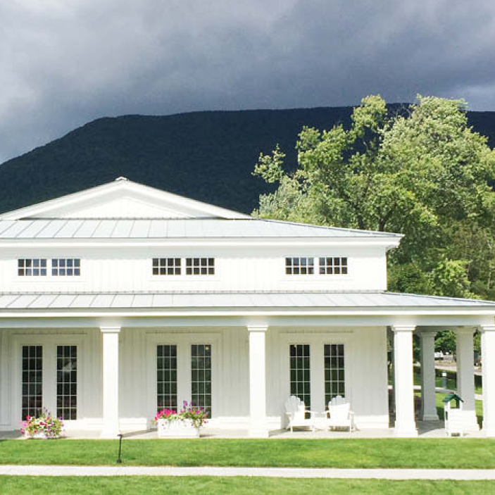 Mount Equinox Hotel in Vermont, a timeless white structure with columns, windows, and French doors, offering Boston Interior Design Inspiration.