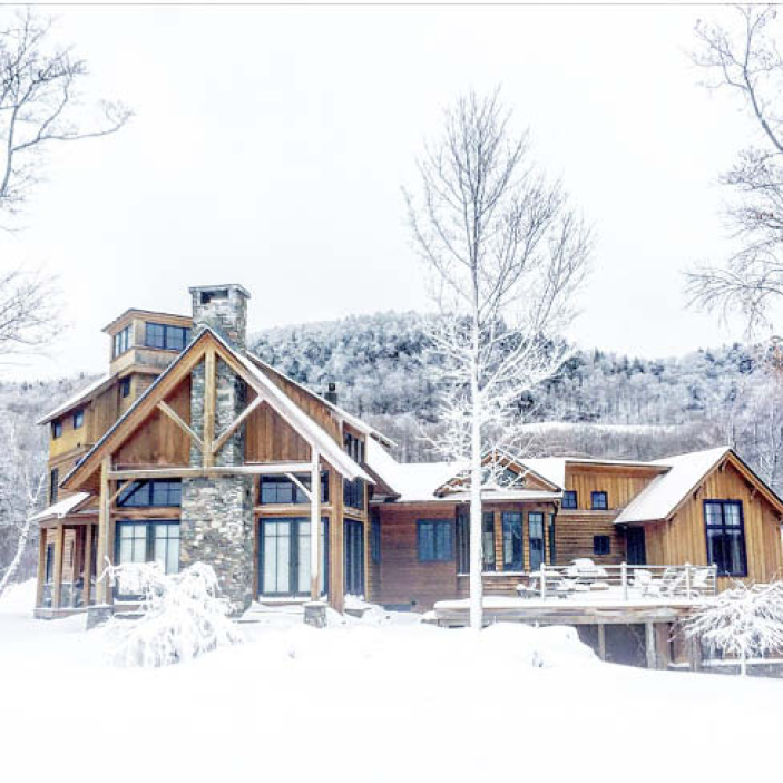 Ski chalet on Stowe Mountain, Vermont, in a snowstorm, showcasing nature-inspired architectural design and winter embracing elements.