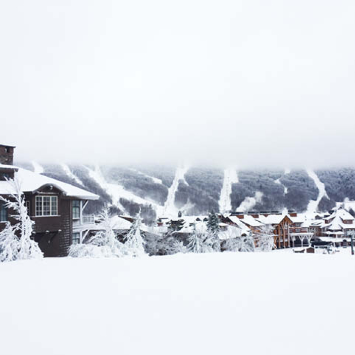 A ski chalet overlooking snow-covered trails at Stowe Mountain, Vermont, offering Boston Interior Design Inspiration with winter landscape elements.