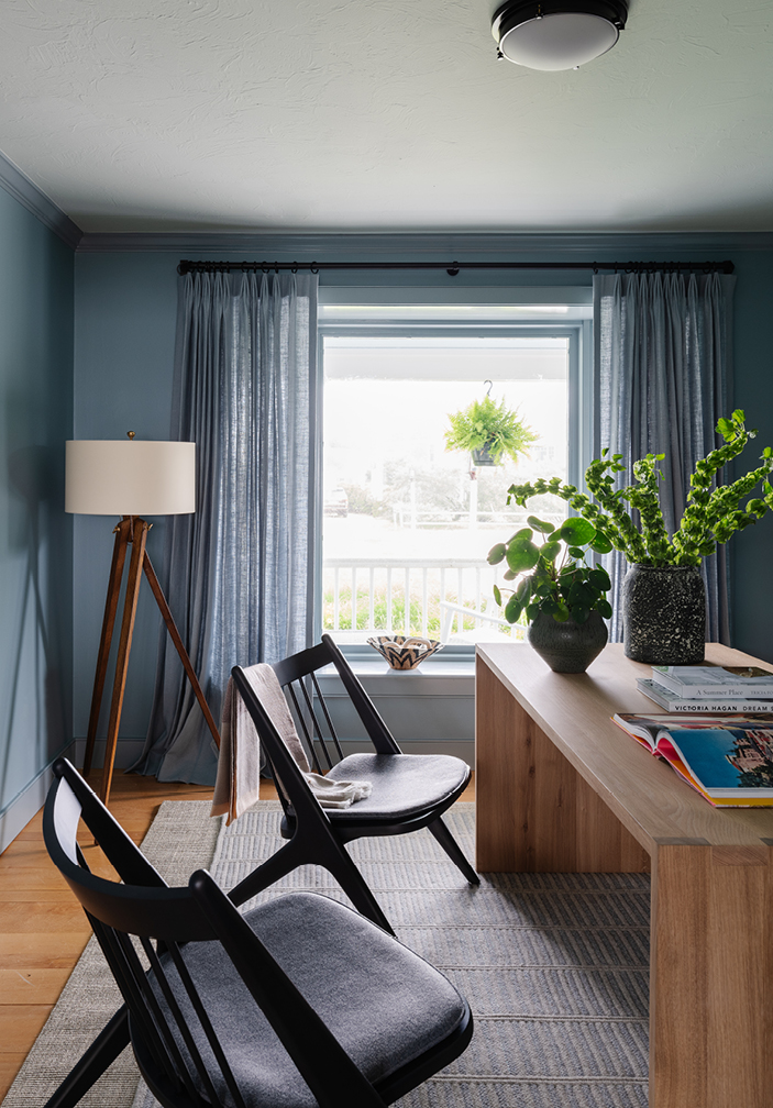 Home office in an Edgartown beach house featuring soft blue walls and ceiling, monochromatic drapery, and a custom carpet. A modern waterfall desk pairs with black lounge chairs, designed by Boston interior designer Sarah Scales to reflect coastal and New England interior design.