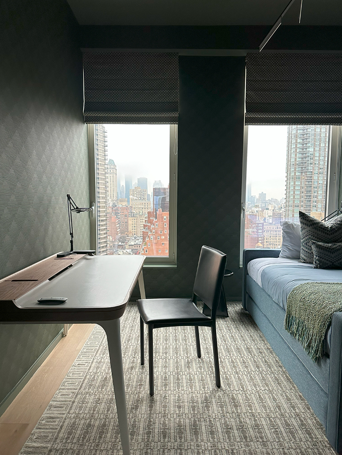 Boys' bedroom with Zak+Fox dark green wallpaper, a custom blue trundle bed, and a modern desk by Design Within Reach, showcasing NYC interior design.