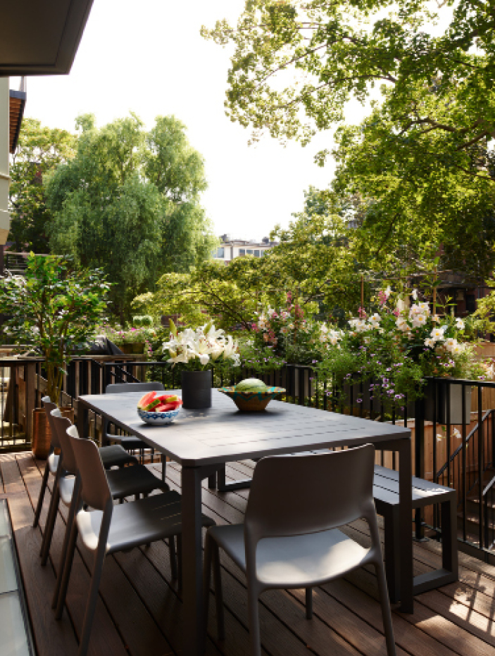 Deck off the kitchen of a historic Boston brownstone featuring a small area with just enough space for a dining table and grill. Highlighting New England interior design by Boston interior designer Sarah Scales.