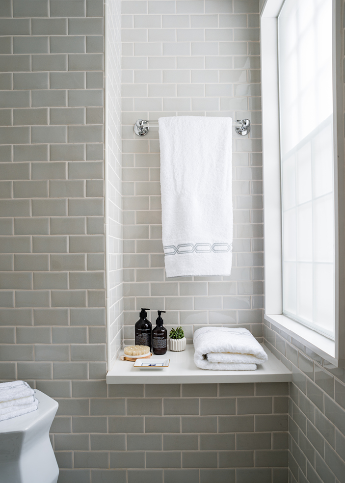 Dover primary bathroom with neutral wall tile, niche, bench, and simple accessories. Light and airy design with natural light by Boston kitchen and bath designer Sarah Scales.