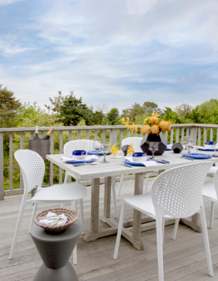 Edgartown beach shack featuring a deck with modern furniture, designed by a Cape Cod interior designer for coastal living.