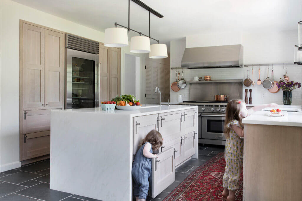 A modern Westwood kitchen with natural oak cabinets and a marble waterfall island. Designed by a Boston kitchen designer.