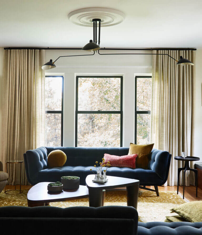 Modern furniture and mid-century-inspired lighting in a renovated Brookline home, featuring neutral tones with subtle color accents.