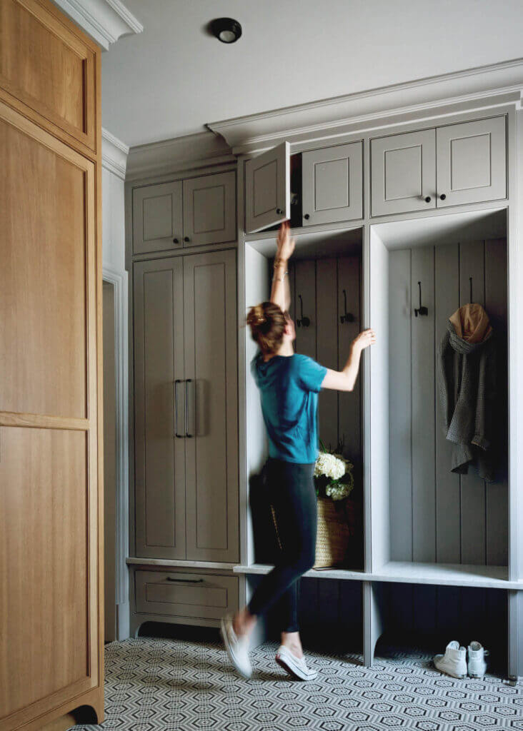 Custom cabinets in a traditional mudroom featuring natural oak and light grey cabinetry, designed by Sarah Scales in a classic Milton home.