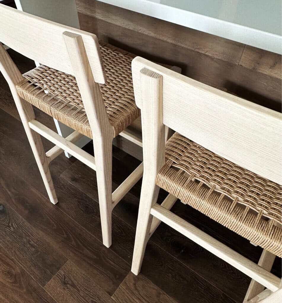 Custom-made ash and natural cording handcrafted counter stools at a kitchen island in a new construction ski house in Stowe, Vermont.