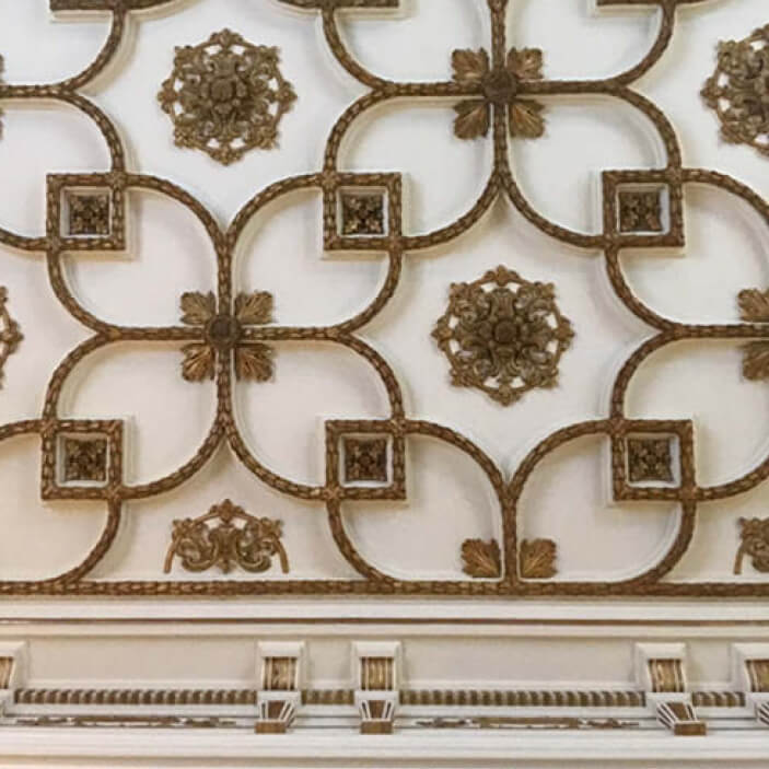 Gilded and white floral motif on an intricately detailed ceiling at Flagler Mansion in Palm Beach, inspiring travel and design by Sarah Scales.