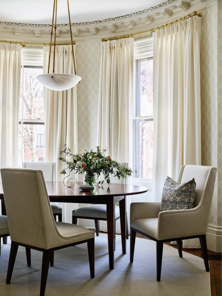 Historic brownstone renovation dining room with classic design, featuring traditional millwork, modern furnishings, and soft lighting.