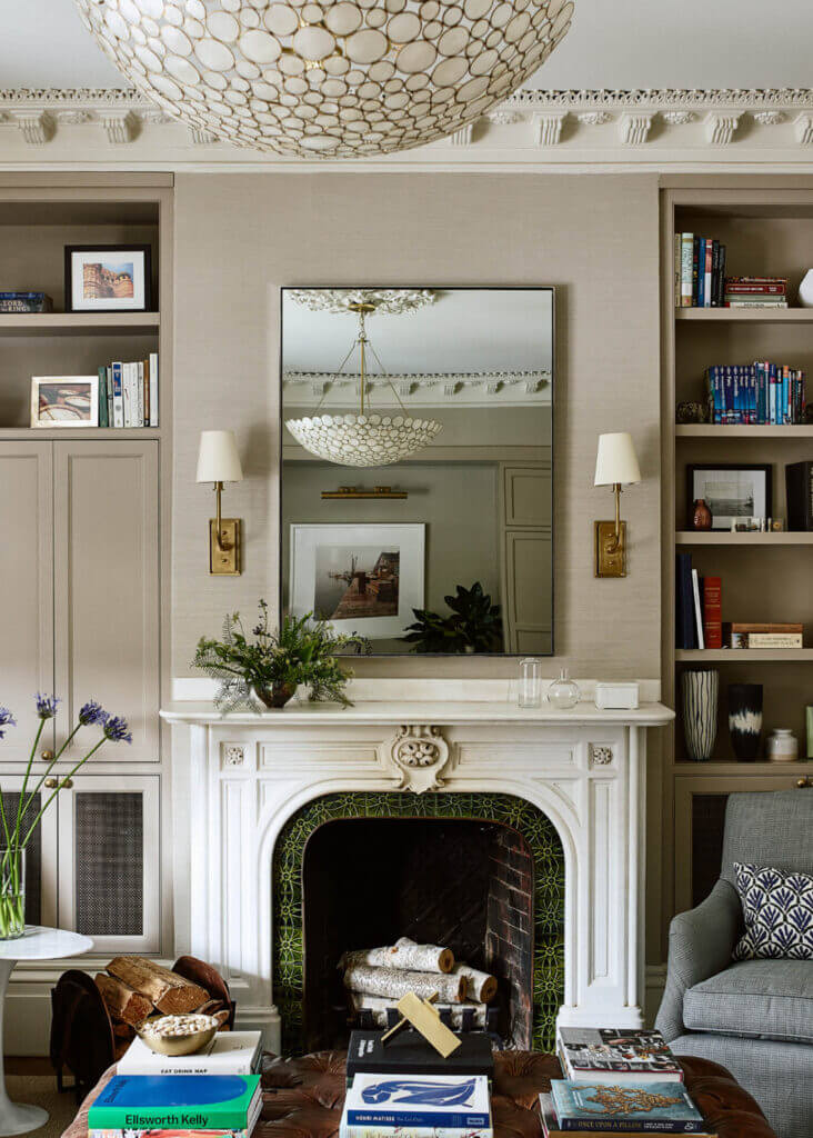 A historic brownstone’s original marble fireplace with green tile and custom millwork blends function and historic home fireplace design seamlessly.