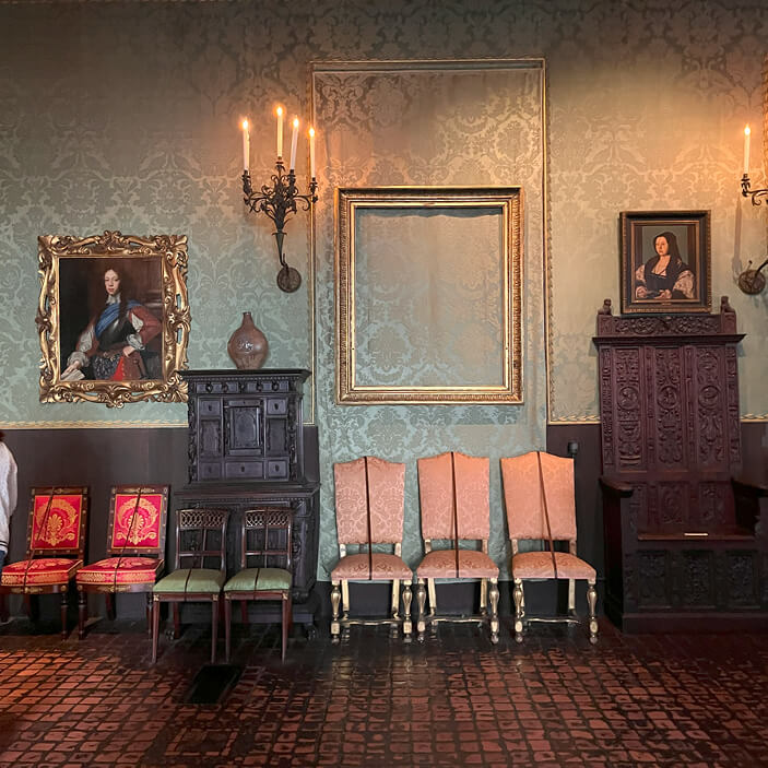 Inspiration from Boston’s Isabella Stewart Gardner Museum, featuring original flooring, silk wall panels, and the empty gilded frame of a stolen Rembrandt.