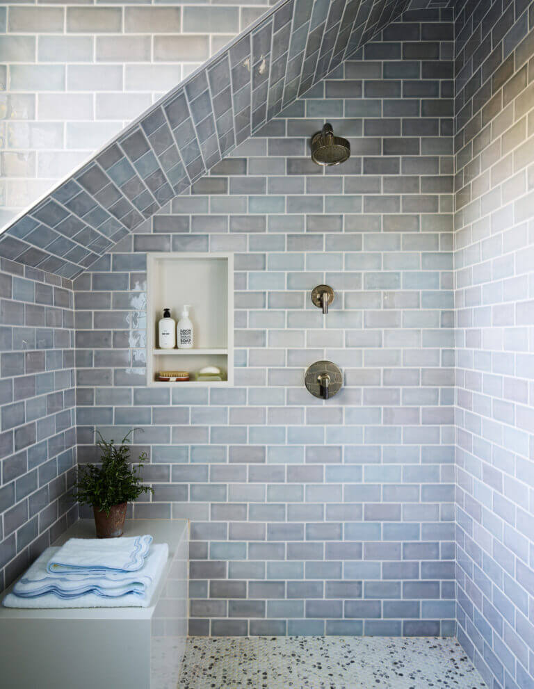 Custom walk-in shower with soft blue subway tiles, polished nickel Kallista fixtures, and a quartz bench. Boston kitchen and bath design.