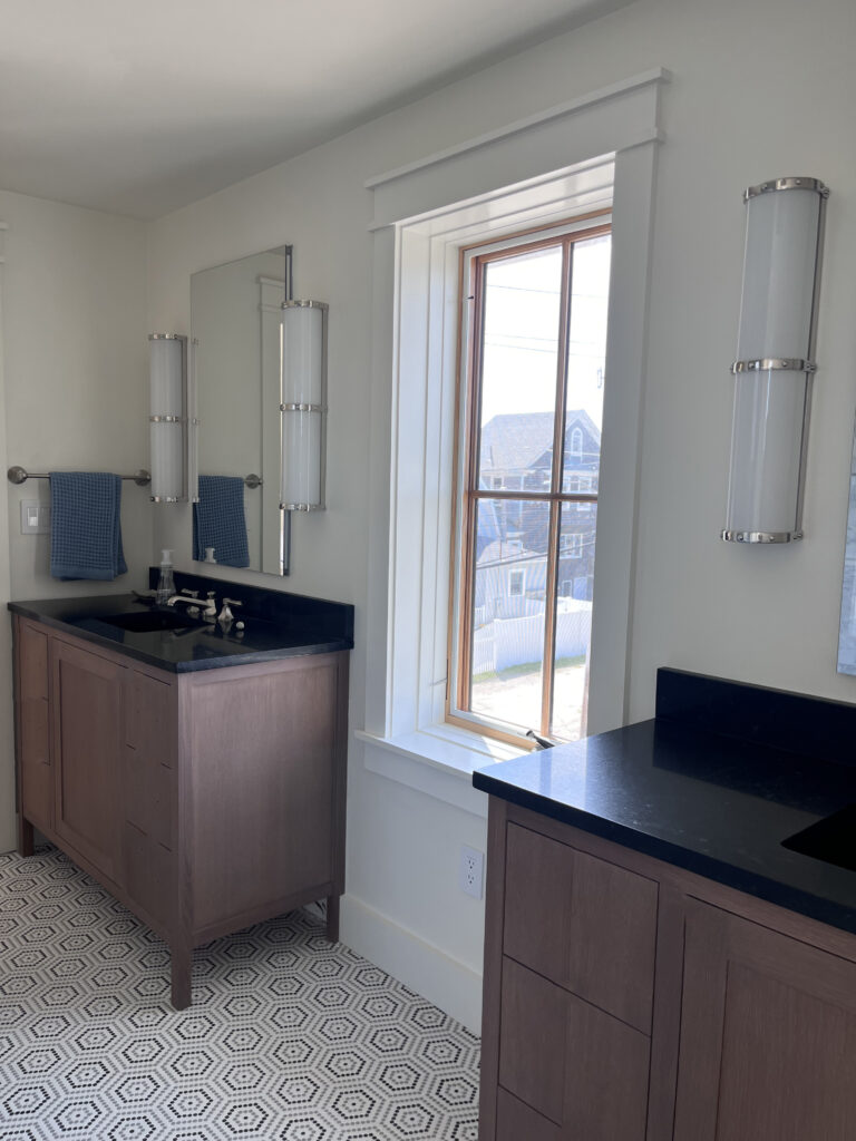 Custom vanities with Ann Sacks tile and Visual Comfort sconces in a South Shore beach house bathroom by a Boston interior design firm.