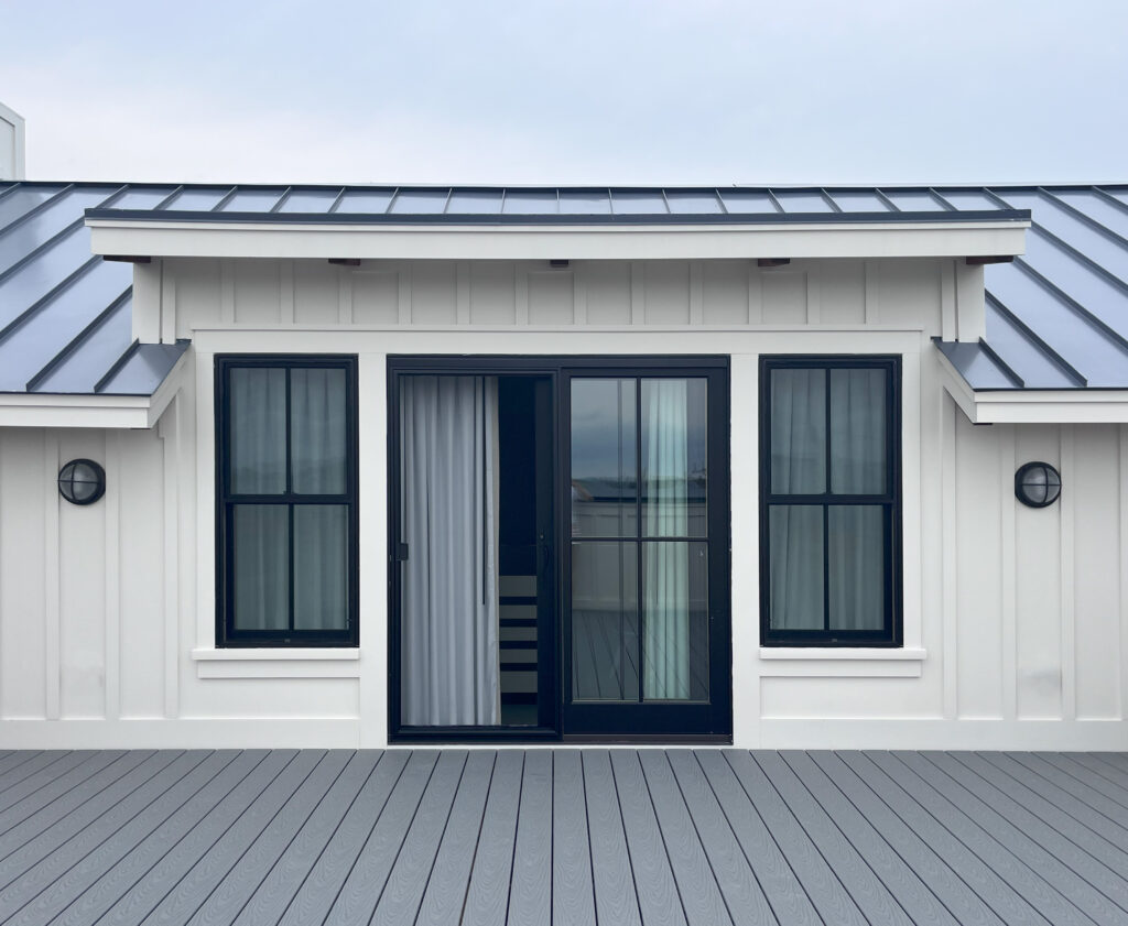 White board and batten exterior with black windows at a new construction beach home on Boston’s South Shore by a Boston interior decorator.