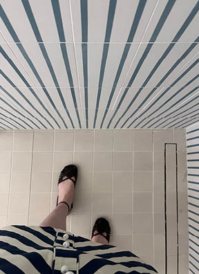 Bathroom with off-white floor tile and striped wall tile in a new build home on Boston’s South Shore by top interior designers.