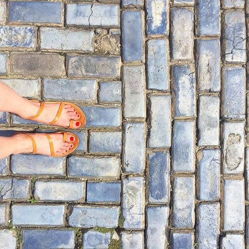 Travel inspiration—blue patterned tiles in Puerto Rico, captured with beige sandals worn by Sarah Scales.