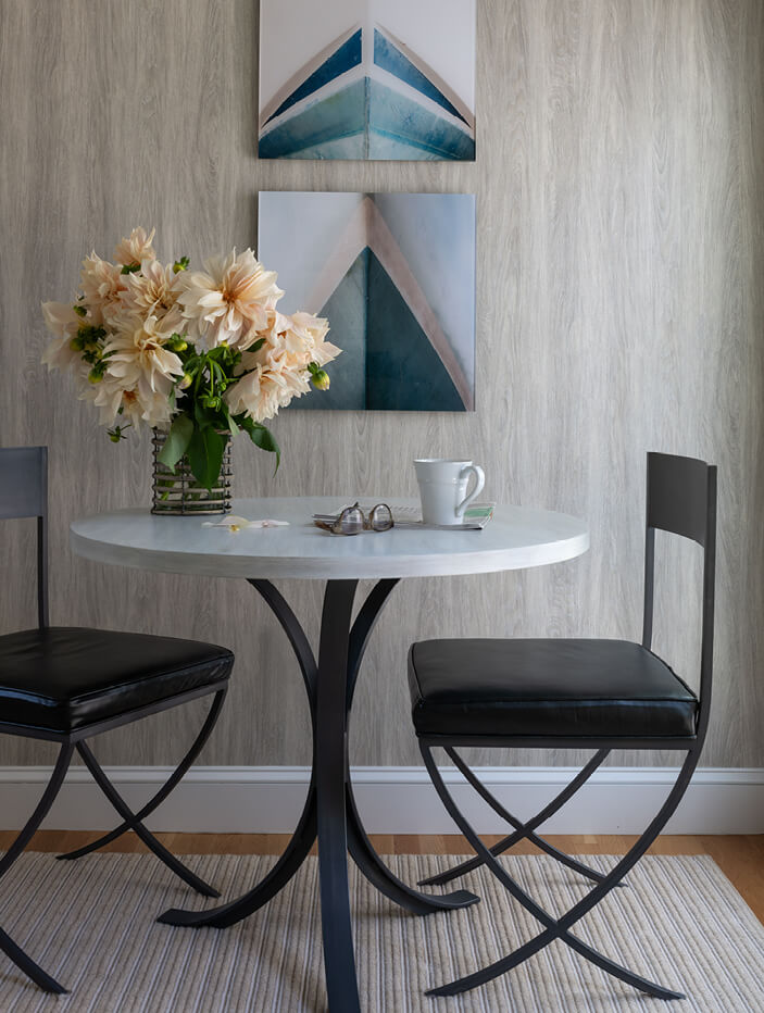 A Hingham home coffee nook with a bistro table and leather dining chairs. Designed by Hingham interior designers and a Boston interior decorator.