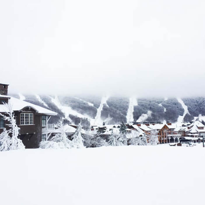 Travel inspiration from ski home architecture in Stowe, Vermont—classic mountain design with ski trails in the background.