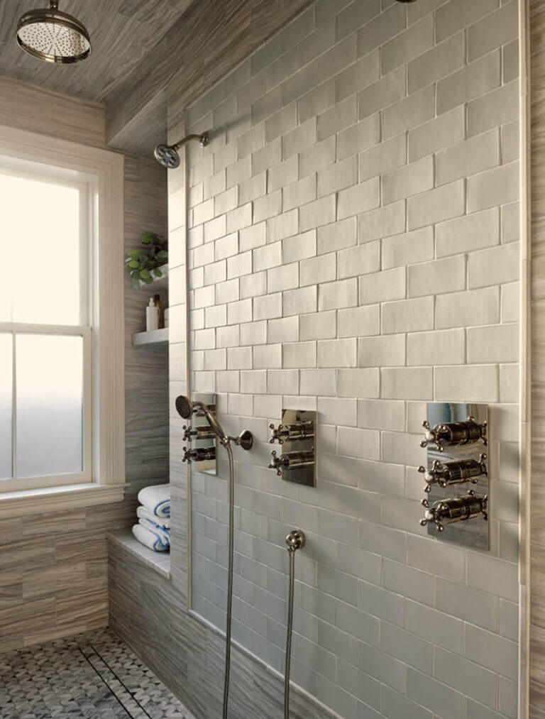 Historic brownstone renovation walk-in shower with Samuel Heath fixtures, Waterworks tile, and stone walls with ceramic tile details.