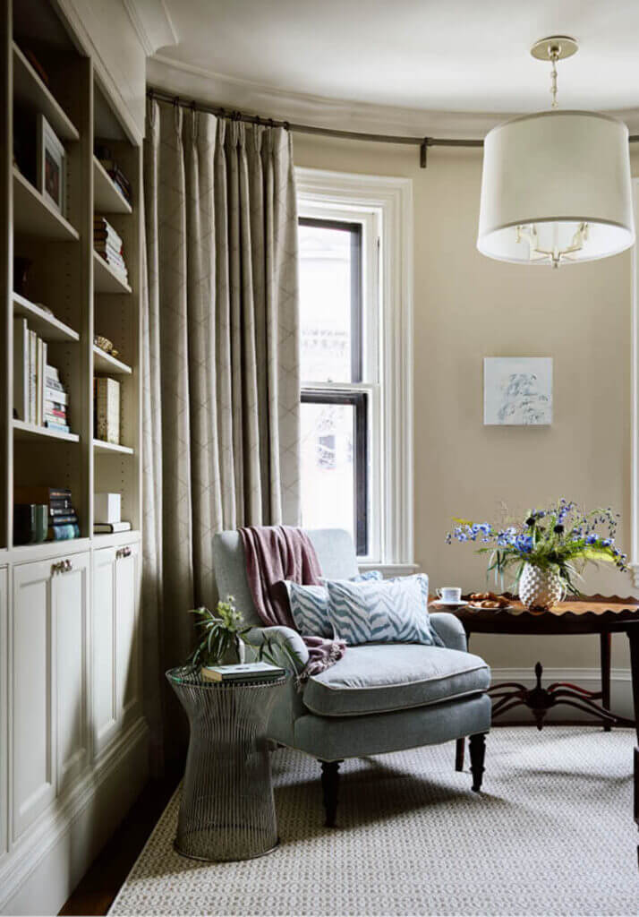 Custom cabinets in a primary bedroom with a patterned wool rug, vintage table, and modern accents in a historic brownstone renovation.