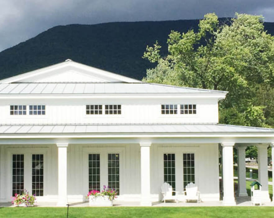 Classic Vermont architecture with French doors and columns—New England design inspiration.