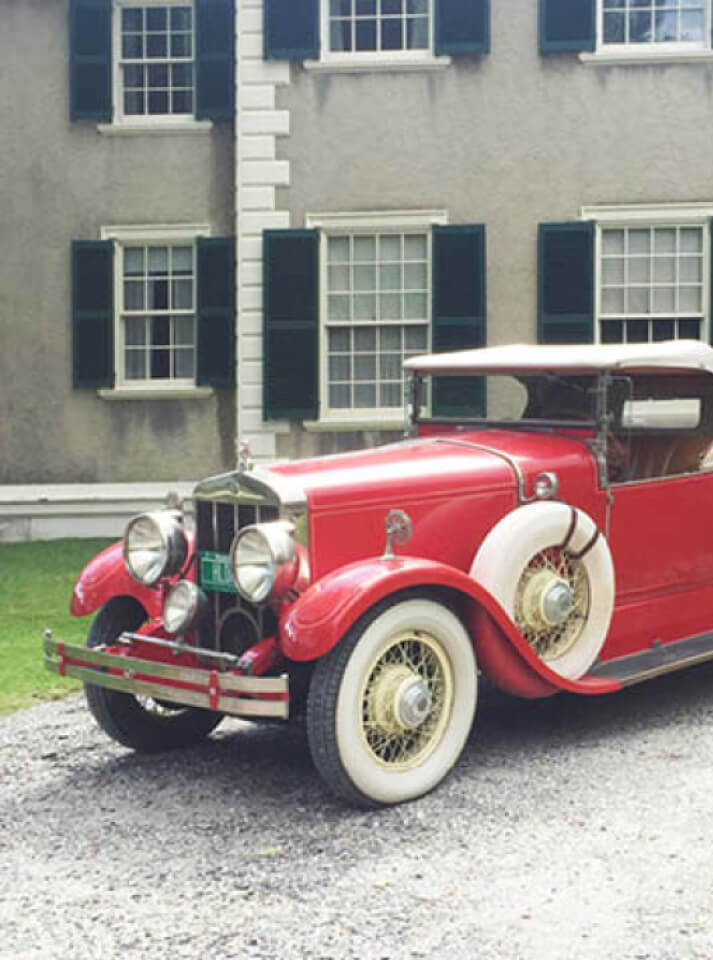 Classic red vintage car at a historic Vermont estate—New England design inspiration.